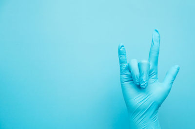 Close-up of hand over blue background