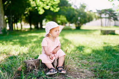 Cute boy sitting on grass