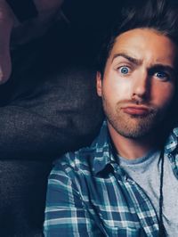 Close-up portrait of young man making face at home