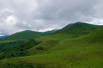 Scenic view of green mountains against sky