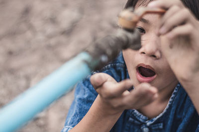 Close-up of girl drinking water from tap