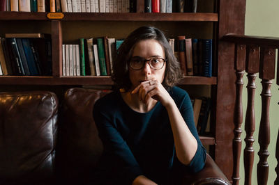 Portrait of young woman sitting on book