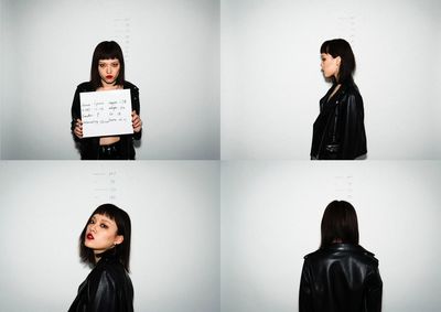 Portrait of young woman standing against wall