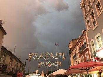 Low angle view of illuminated buildings in city against sky