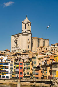 Buildings in city against clear blue sky