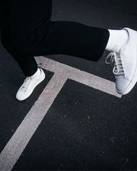 Low section of man standing on road