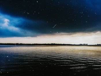 Scenic view of lake against sky at night