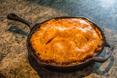 High angle view of apple pie in pan on table