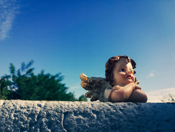 Portrait of woman sitting against blue sky