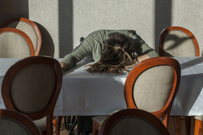 Rear view of woman sitting on chair