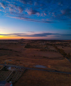 Scenic view of arid landscape against sky during sunset