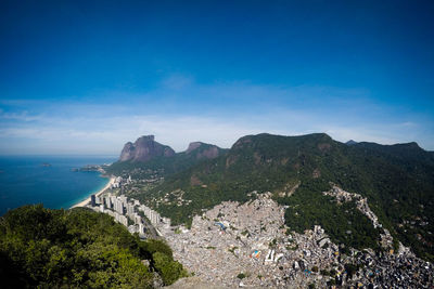 Scenic view of sea and mountains against blue sky