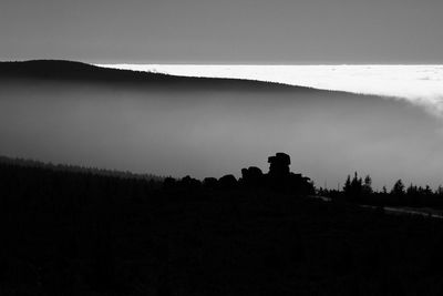 Silhouette people on land against sky