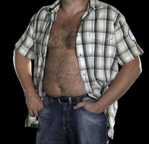 Midsection of man standing against black background