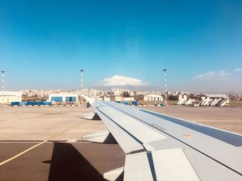 Airplane on airport runway against blue sky