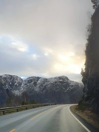 Road by mountains against sky