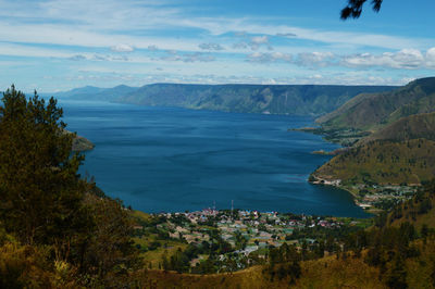 Scenic view of sea and mountains against sky