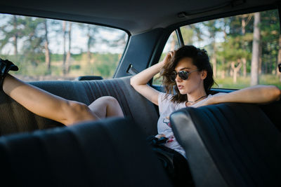 Portrait of a hipster girl in the back seat of a car.