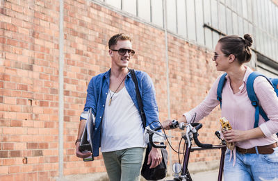 Young couple with bicycle walking and talking