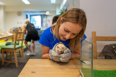 Woman playing with porcupine on table