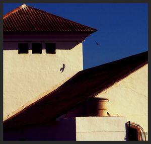 Low angle view of houses against blue sky