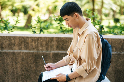 Mid adult man sitting on book