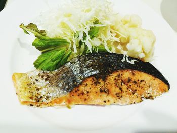 Close-up of grilled fish with vegetables in plate