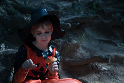 Portrait of cute boy sitting outdoors