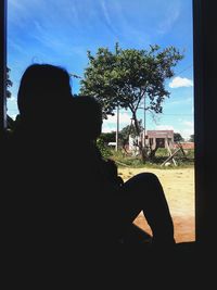 Silhouette of man sitting against sky