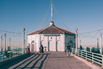 People walking against blue sky