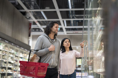 Young couple shopping during inflation in supermarket