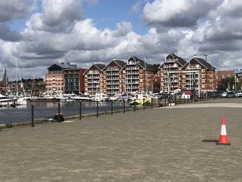 Sailboats on beach by buildings against sky in city