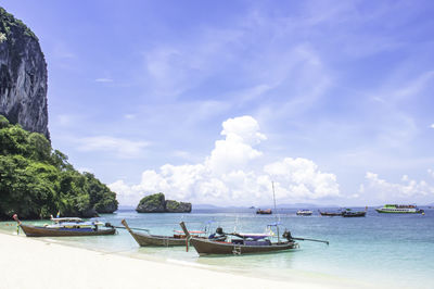 Lots of boat tours and tourists on the beach at poda island , krabi in thailand.