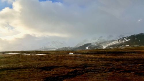 Scenic view of mountains against cloudy sky