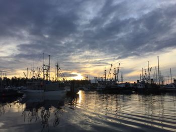 Sailboats in sea at sunset