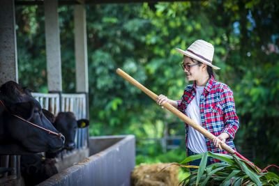 Midsection of woman holding hat while standing outdoors
