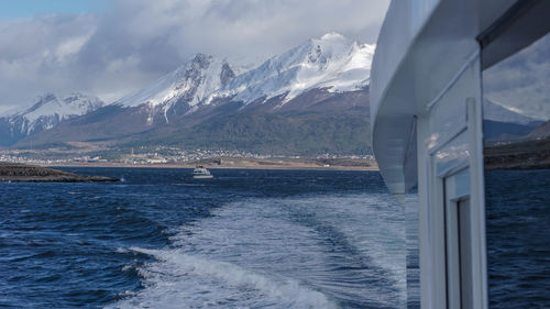 Scenic view of sea and snowcapped mountains against sky