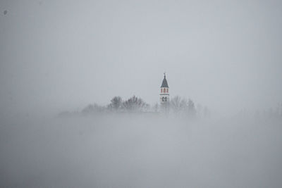 Church against sky during winter, in the fog