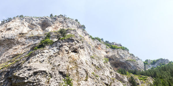 Low angle view of rocks against clear sky