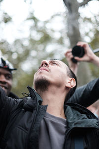 Portrait of young man photographing outdoors