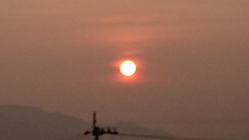 Scenic view of moon against orange sky