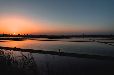 Scenic view of lake against orange sky