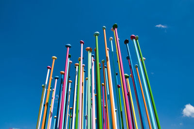 Low angle view of multi colored umbrellas against blue sky