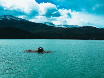 Scenic view of sea  and mountains against sky 