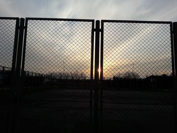 Fence against sky during sunset