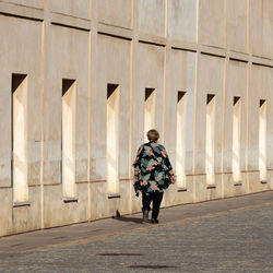 Rear view of man standing against building