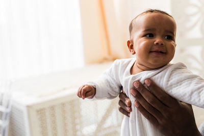 Cropped hand of father holding son at home