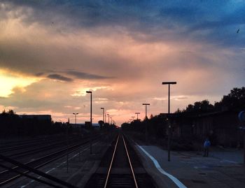 Railroad tracks against cloudy sky