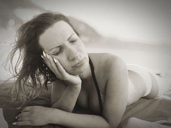 Close-up of young woman lying on beach