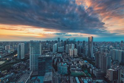 Aerial view of buildings in city against sky during sunset